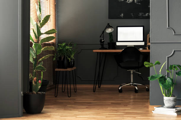 istock Mockup on computer desktop next to lamp in grey freelancer's room interior with plants. Real photo 1002133066