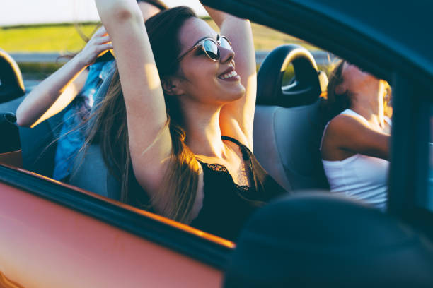 istock Young women on a road trip with cabriolet 1002135404
