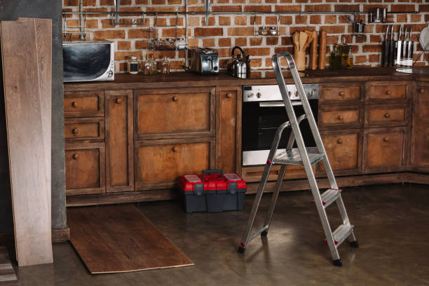 interior of loft style kitchen with stepladder, toolbox and laminate planks on floor
