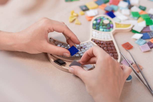 istock Hands of master working on new modern colorful mosaic. Close-up 1002145164