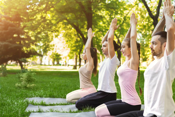istock Group of people practicing yoga in park 1002145214