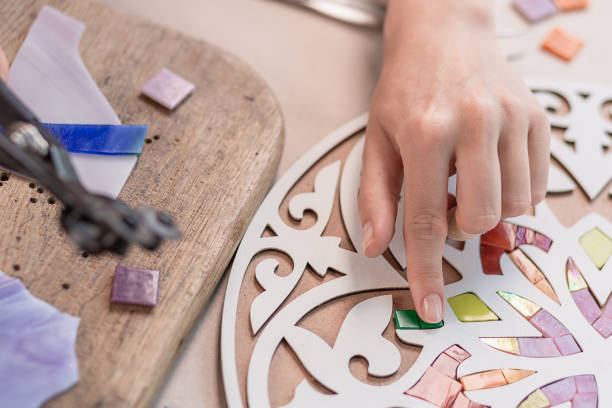 istock Hands of master working on new modern colorful mosaic. Close-up 1002148622