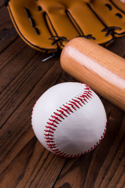 istock Baseball bat, ball and glove wooden table. Closeup 1002149640