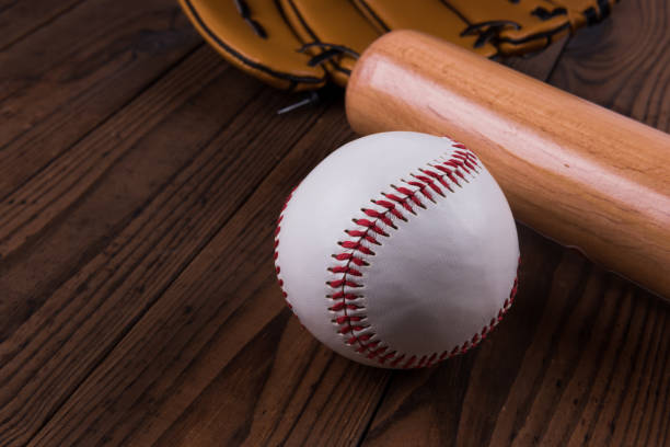 istock Baseball bat, ball and glove wooden table. Closeup 1002149930
