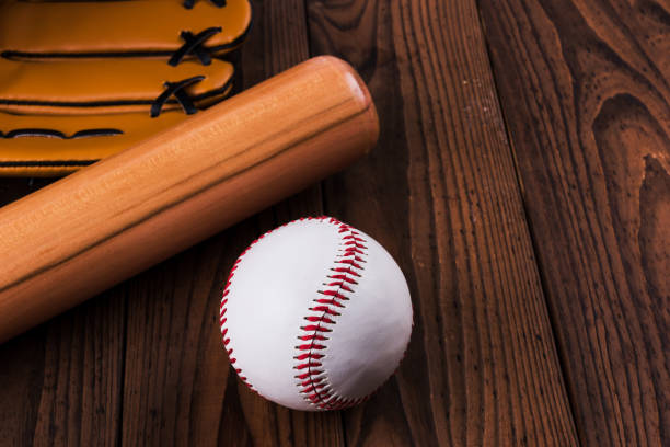 istock Baseball bat, ball and glove wooden table. Closeup 1002149936