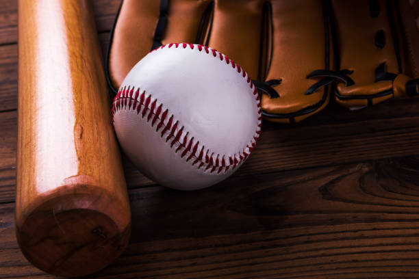 istock Baseball bat, ball and glove wooden table. Closeup 1002153020