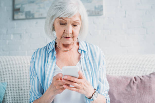 istock portrait of senior woman using smartphone while resting on couch at home 1002153266