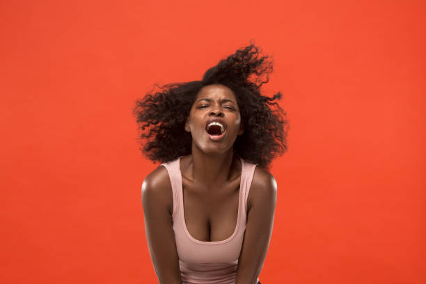 istock The young emotional angry woman screaming on red studio background 1002154272