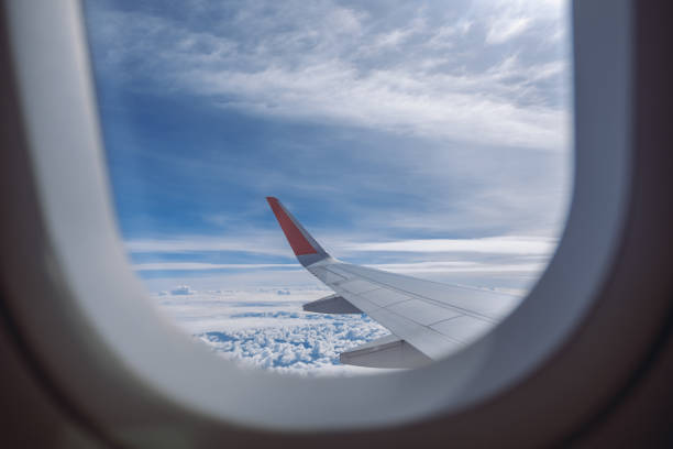 istock Aircraft wing and blue sky on cloudy day through the window 1002157918