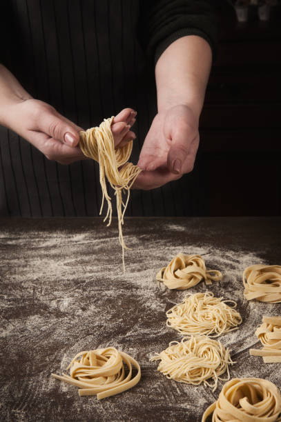 istock Woman making tagliatelle nest on kitchen table 1002157970