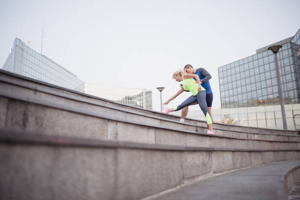 istock Young couple, athletes, stretching after training  in the urban environment 1002158888