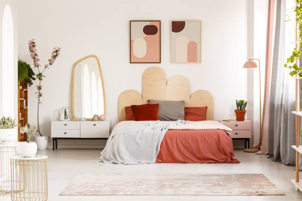 moderne poster über bett mit kopfteil in pastell schlafzimmer innenraum mit spiegel. echtes foto - spiegelschrank mit beleuchtung stock-fotos und bilder