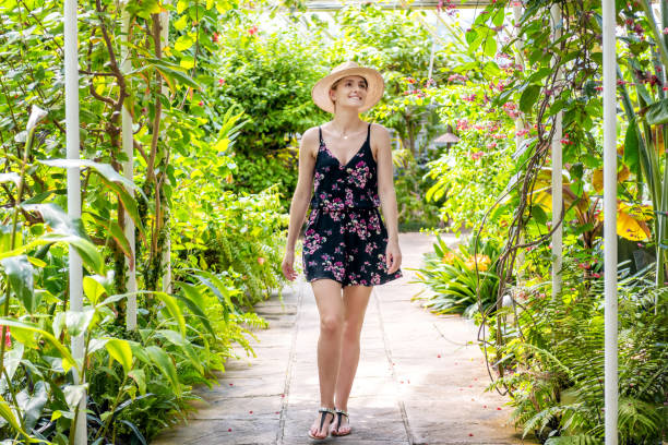 Woman visiting in tropical garden Beautiful woman enjoying beauty of tropical forest, walking on footpath. Surrounded by tropical nature. botanical garden photos stock pictures, royalty-free photos & images