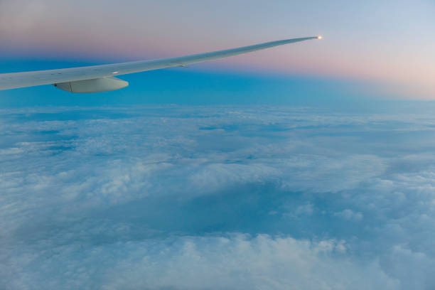 istock Airplane Wing in Flight from window, sunset sky ,West Asia 1002167960