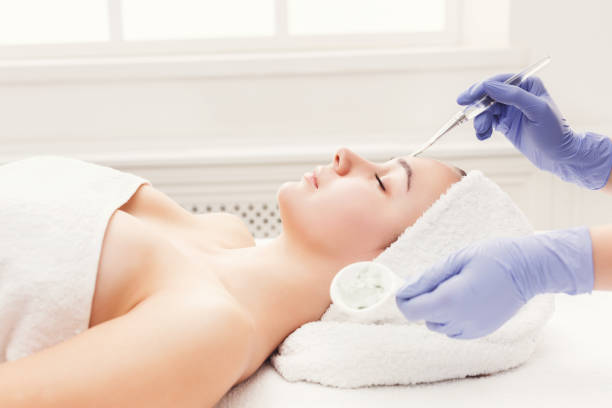 Woman gets face mask by beautician at spa