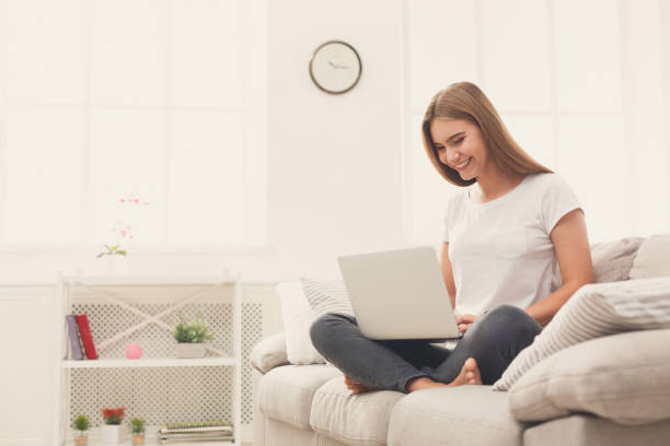 istock Young happy girl using laptop at home 1002180116