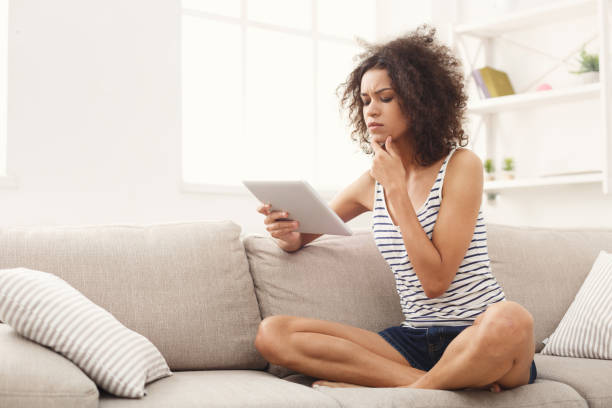 istock Young pensive girl with digital tablet at home 1002181244