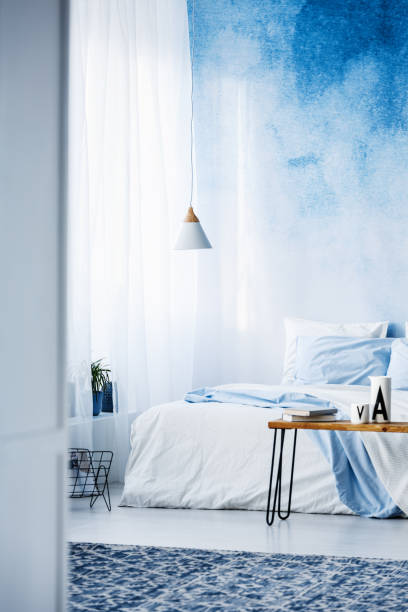 istock Patterned rug in modern, pastel blue bedroom interior with bed against ombre wall 1002181360