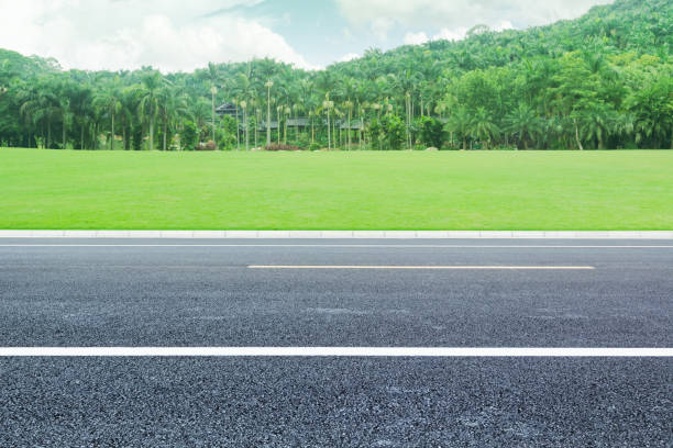 istock Asphalt pavement under blue sky and white clouds, background road materials for automobile advertising 1002181864