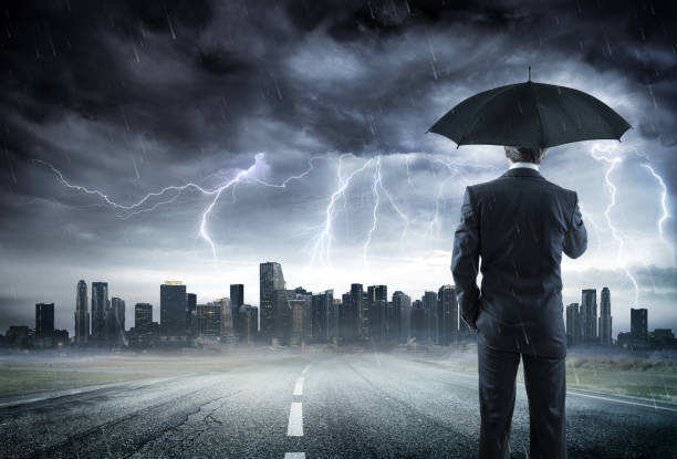 businessman with umbrella looking storm over city - lightning thunderstorm storm city imagens e fotografias de stock