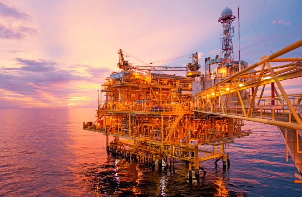 istock Offshore construction platform for exploration and production oil and gas with bridge in evening time for power energy of the world concept. 1002184604