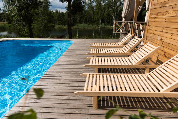istock empty cozy chaise lounges near swimming pool 1002208304