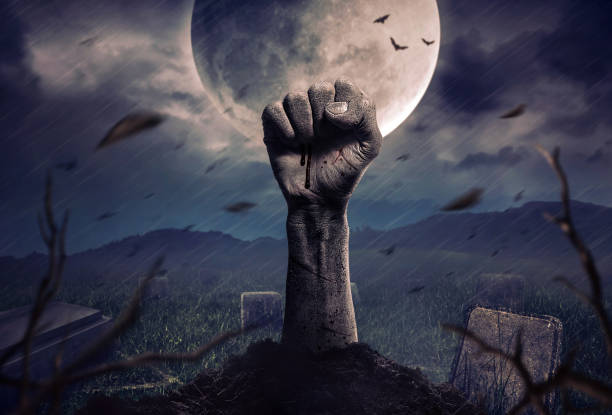 istock Zombie hands rising in dark Halloween night. 1002208446