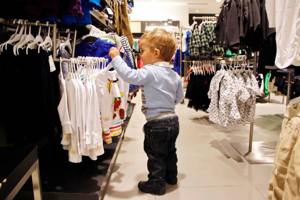 istock Child chooses clothes in store 1002211776