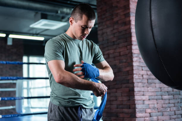 istock Dark-haired fighter standing in modern light gym 1002212152