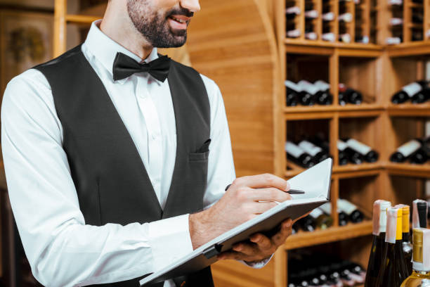istock cropped shot of smiling young wine steward making notes at wine store 1002216184