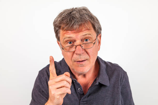 istock handsome man with reading glasses and finger gesture as warning 1002216326