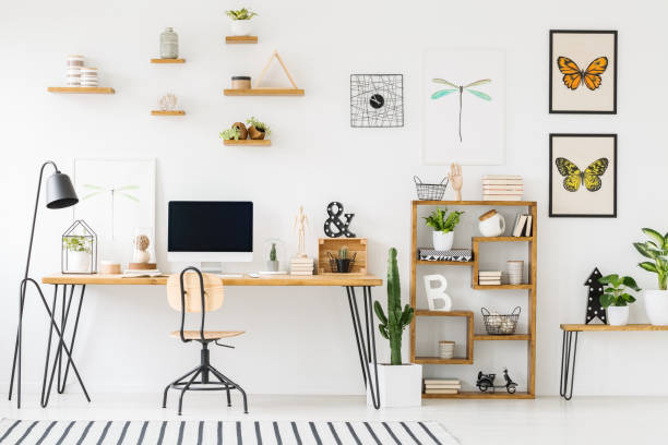 istock Modern home office interior with a wooden desk, chair, shelves, computer with empty screen and plants 1002216480
