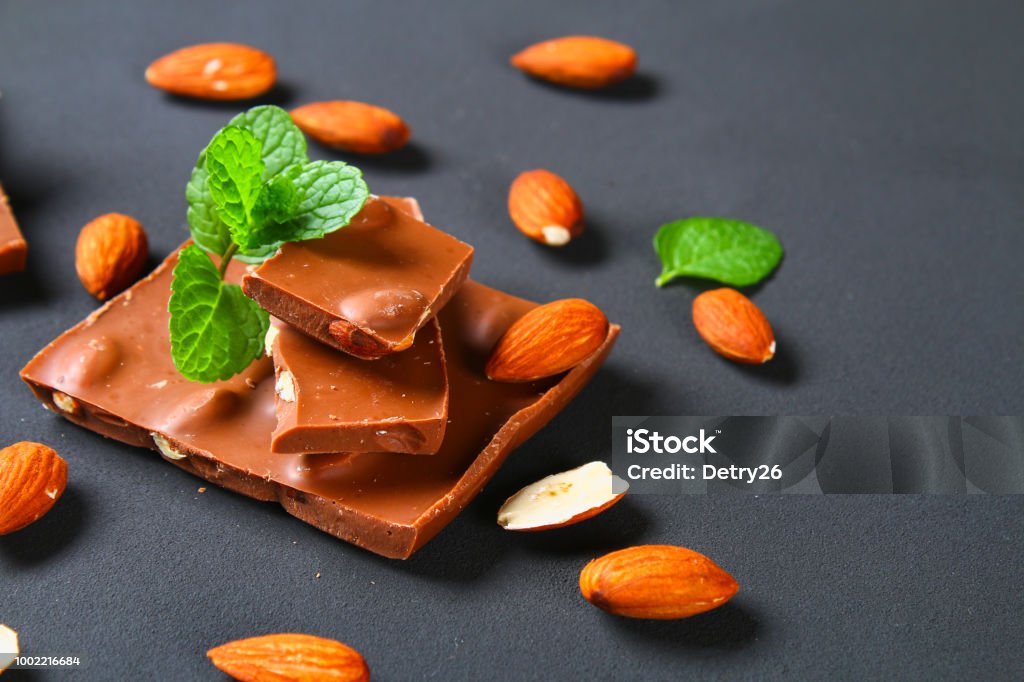 chocolate with almonds on dark grey background. chocolate with almonds on dark grey background Almond Stock Photo