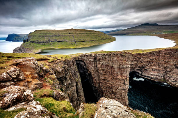 istock Rocks In Sea Against Cloudy Sky 1002218576