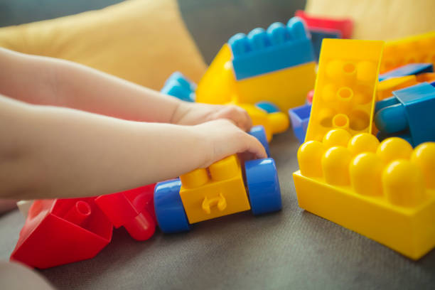 istock Little girl playing with colorful plastic blocks 1002238272