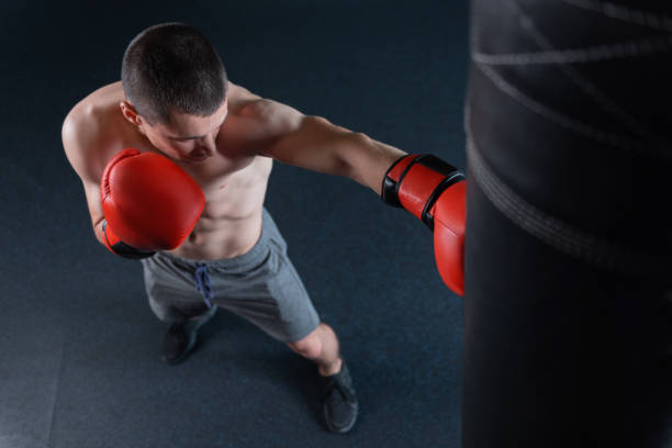 istock Athletic man on steroids working hard with punching bag 1002240048