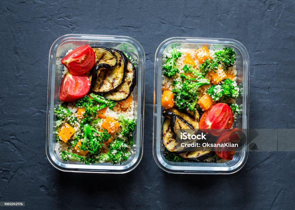 Vegetarian lunch box. Broccoli, pumpkin, couscous salad, grilled eggplant and tomatoes. Healthy diet home food concept. Office food. On dark background, copy space Take Out Food Stock Photo