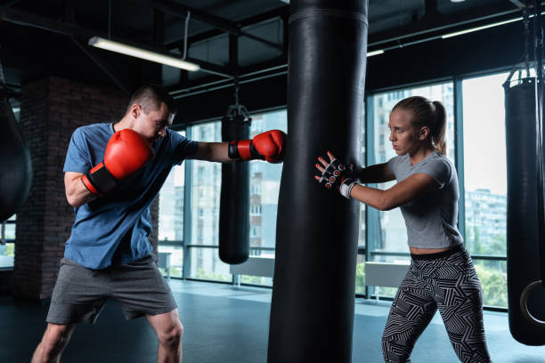 istock Blonde-haired wife supporting her husband working as professional boxer 1002244500