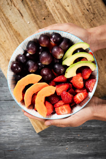 istock man with a bowl of fruit salad 1002254928