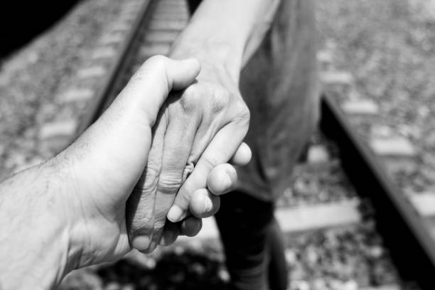 men holding hands on the railroad tracks