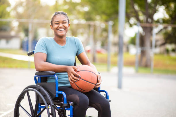 ragazza adolescente nera con basket su una sedia a rotelle - basket su sedia a rotelle foto e immagini stock