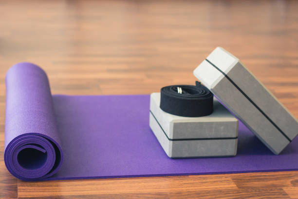 istock Purple yoga mat, grey blocks and black belt on studio floor 1002265540
