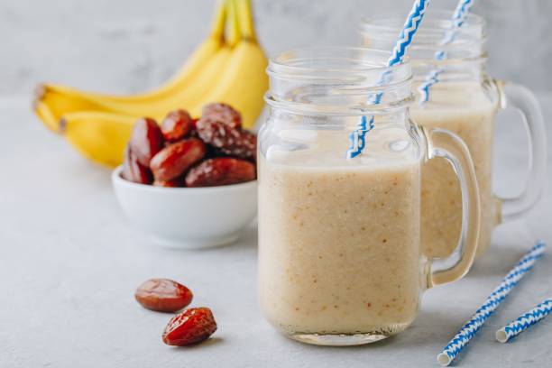 smoothie aux fruits de banane et de la date ou milkshake dans bocal mason - nut spice peanut almond photos et images de collection