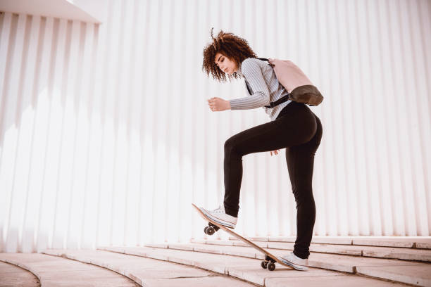 istock Sensual Female Making Tricks With Skateboard On Staircase 1002285724