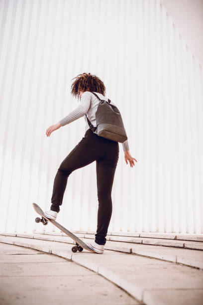 istock Adorable Female Student Riding Skateboard On Ramp 1002285792