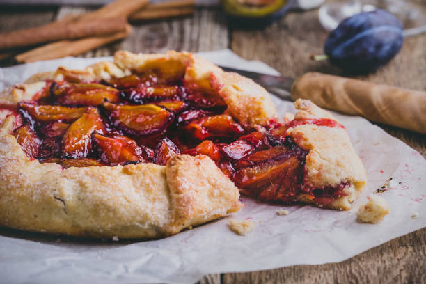 Rustic plum tart on wooden background