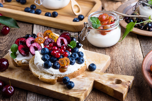 Cream cheese sandwiches with fresh summer berries, healthy breakfast