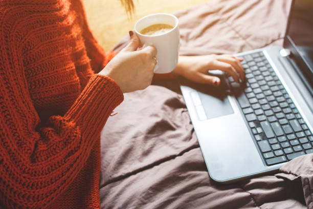 istock Girl typing on laptop and drinking coffee 1002295384