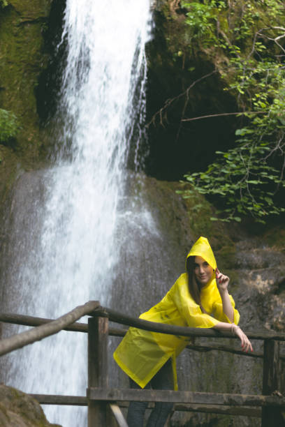 istock Woman in a raincoat on a bridge 1002299320