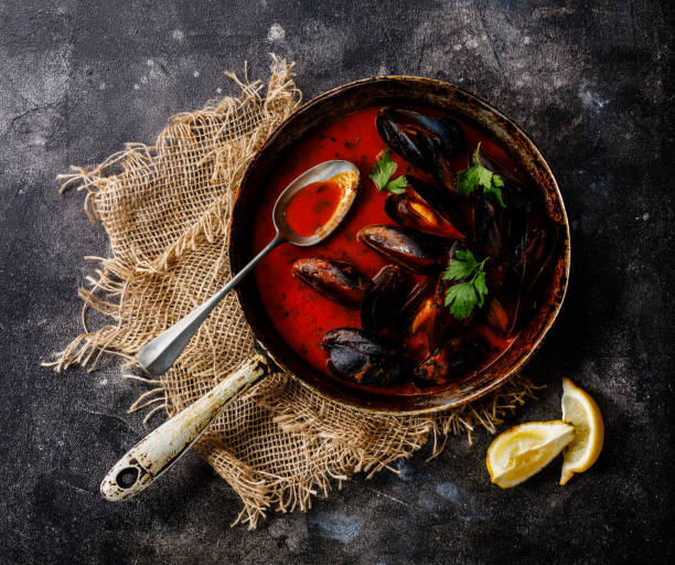 Shellfish Mussels Clams with tomato sauce and parsley in cooking pan